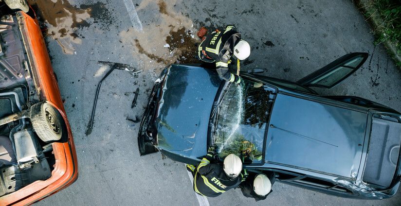 Aerial view of car accident with firefighters