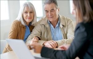 An elderly couple talking with an attorney